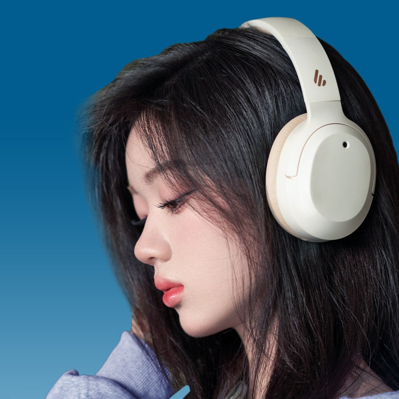 Woman wearing white headphones against a blue background